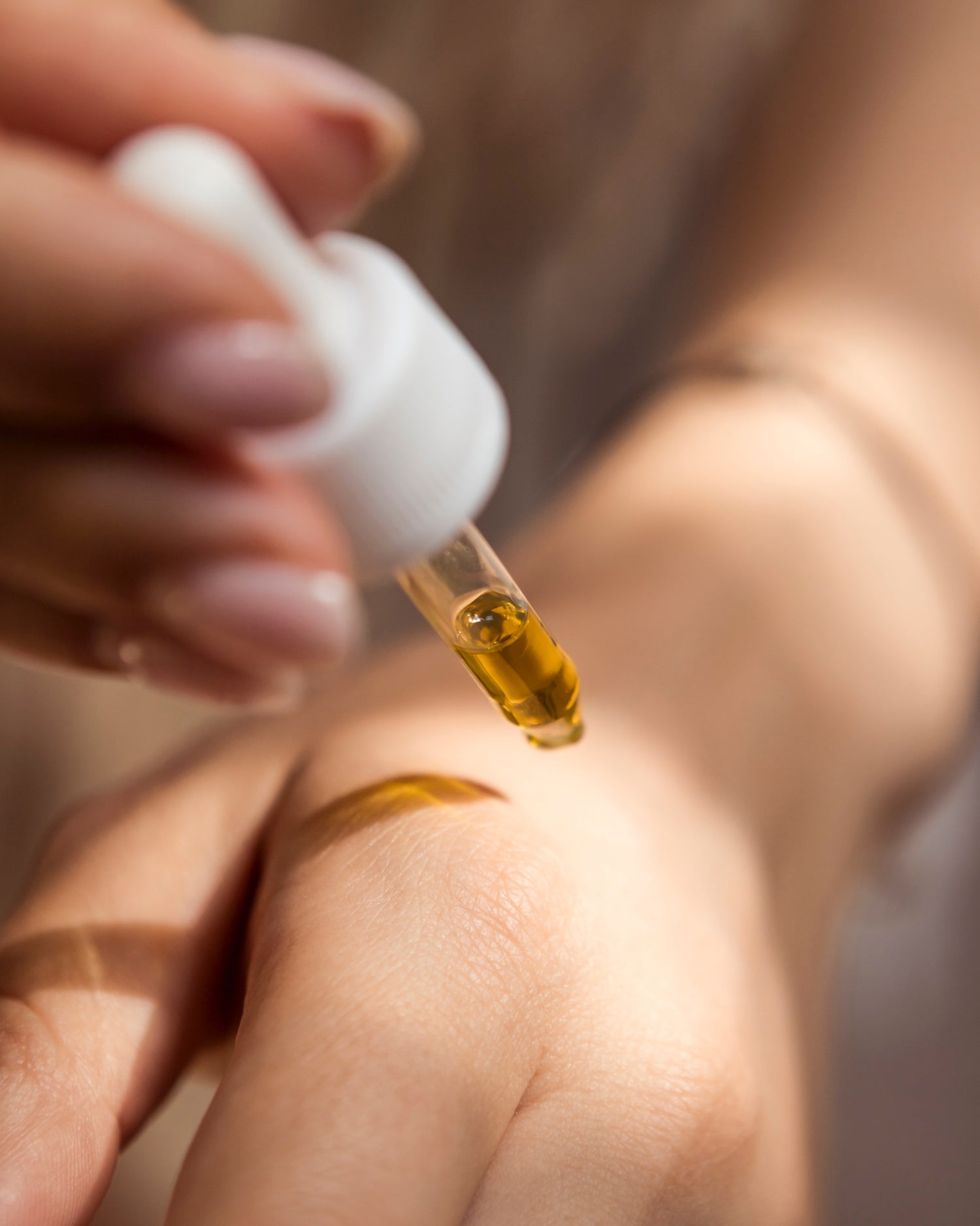 CBD Oel das mit Pipette auf Haut getropft wird