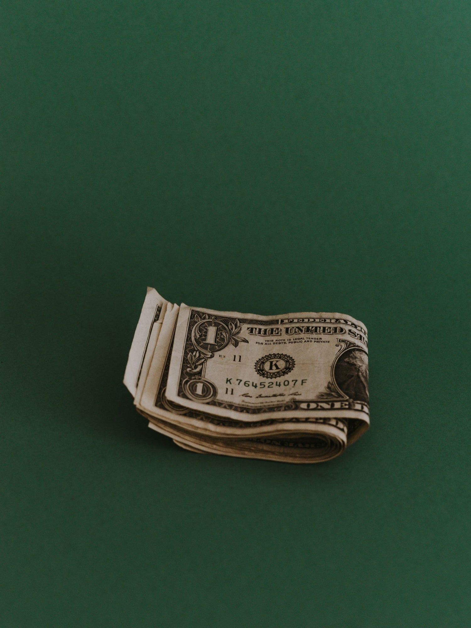 Ein Dollar Scheine auf grünem Hintergrund
